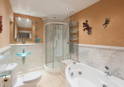 uma casa de banho com uma banheira, um chuveiro e um WC. em The York Place Residence em Edimburgo