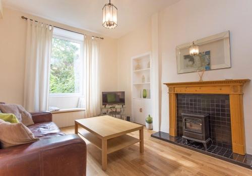 uma sala de estar com um sofá e uma lareira em The Broughton Road Residence em Edimburgo