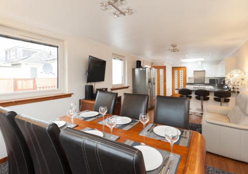 a dining room and living room with a table and chairs at The Traquair Park Residence in Edinburgh