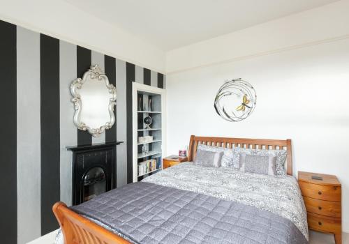 a bedroom with a bed and a black and white striped wall at The Traquair Park Residence in Edinburgh