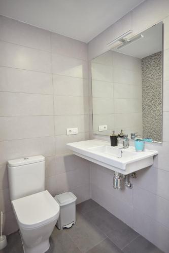 a bathroom with a toilet and a sink and a mirror at Apartamento Sol y Mar in Las Galletas