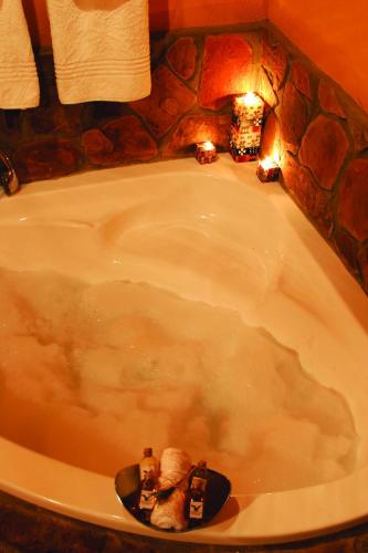 a bath tub with a fireplace in a bathroom at Aquila Private Game Reserve & Spa in Touwsrivier