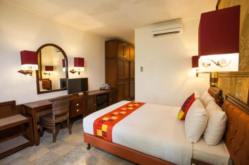 a hotel room with a bed and a desk and a computer at Ari Putri Hotel in Sanur