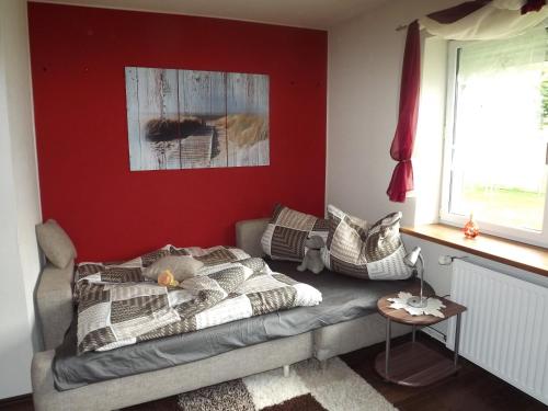 a bedroom with a bed and a red wall at Ferienwohnung Ostseenähe in Schönberg