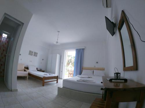 um quarto branco com uma cama e um sofá em Vamvini Hotel em Sarti