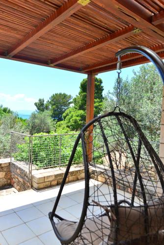 a swinging chair on a porch with a view at PYRGOS RALLI ESTATE Guesthouse in Aegina Town