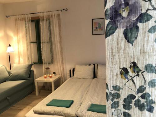 a small bedroom with a bed and a couch at Tulipán Villa Panzió in Szolnok