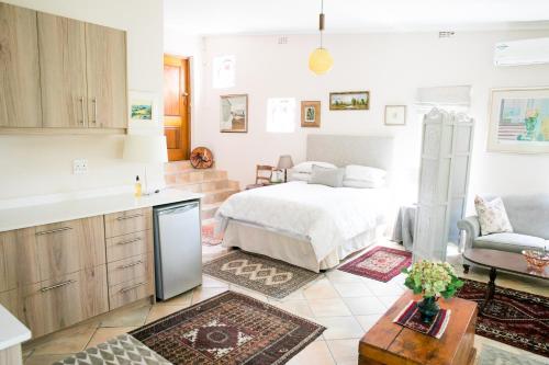 a kitchen and a bedroom with a bed in a room at Villa Pascal Guest House in Durbanville