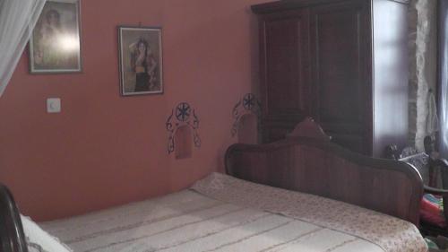 a bedroom with a bed in a red wall at The Pounti in Pyrgi