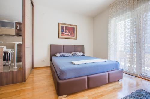 a bedroom with a bed and a large window at Zebra in Podgorica