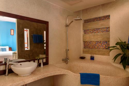 La salle de bains est pourvue d'un lavabo et d'une baignoire. dans l'établissement Indigo House Hotel, à Luang Prabang