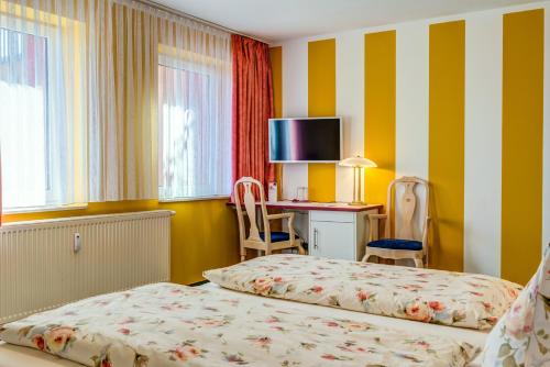 a hotel room with two beds and a desk with a computer at Hotel Traumblick in Oberhof