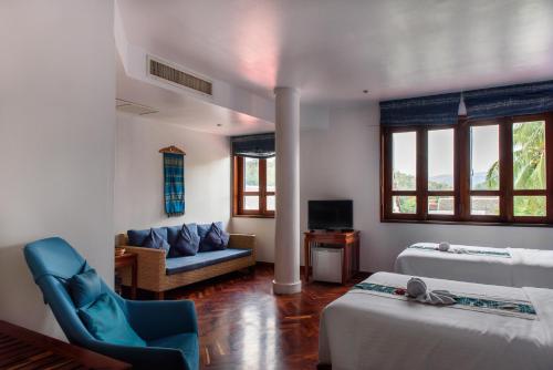 ein Wohnzimmer mit 2 Betten und einem Sofa in der Unterkunft Indigo House Hotel in Luang Prabang