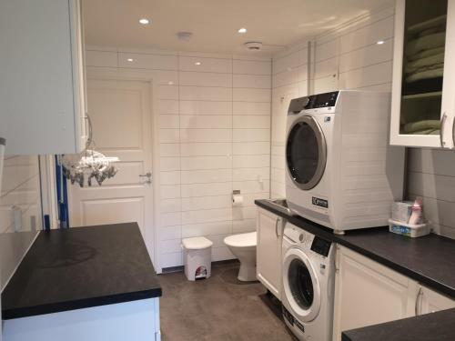 a kitchen with a washing machine and a washer and dryer at Lofoten, Markveien Villa in Kabelvåg