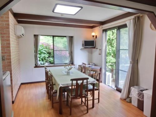 a dining room with a table and chairs and a window at 伊道荘園 in Futo
