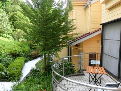 a balcony with a bench and a tree on a house at 伊道荘園 in Futo