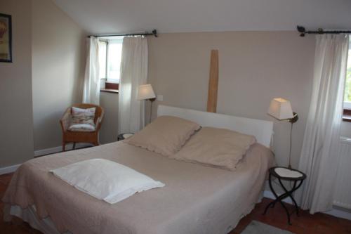 a bedroom with a bed with white sheets and a window at L'Atterrissage in Santes