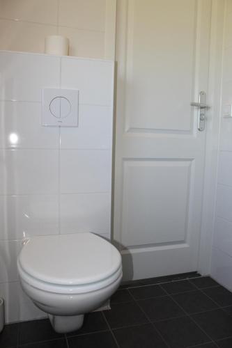 a bathroom with a white toilet and a door at Chaletpark Petzen in Feistritz ob Bleiburg