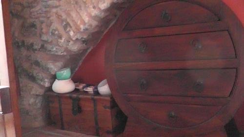 a wooden dresser with a green bottle on a table at The Pounti in Pyrgi