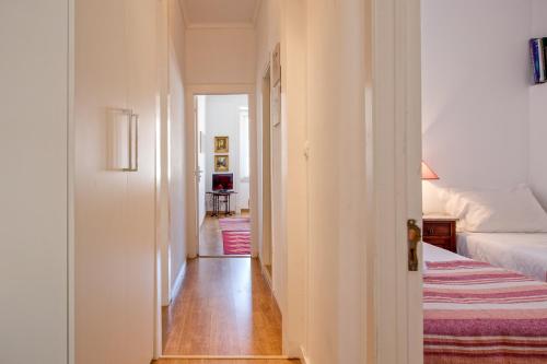 um corredor que leva a um quarto com uma cama em Alfama River View Tailor Made Flat em Lisboa