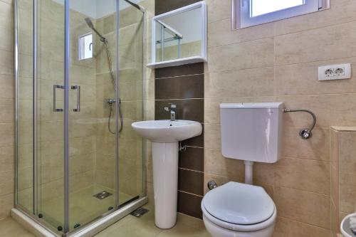 a bathroom with a toilet and a sink and a shower at Apartments Venezia in Sutomore