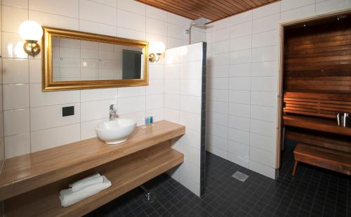 W łazience znajduje się umywalka i lustro. w obiekcie Grand Hotel Mustaparta w mieście Tornio