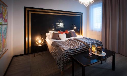 um quarto com uma cama king-size e uma mesa em Grand Hotel Mustaparta em Tornio