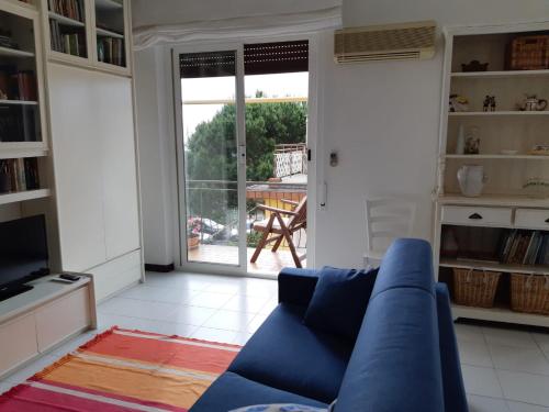 a living room with a blue couch and a sliding glass door at APPARTAMENTO nonni FRANCHI in Loano