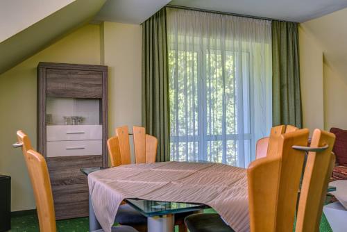a dining room with a table and chairs and a window at Hotel Traumblick in Oberhof