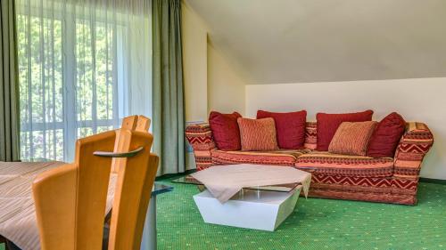 a living room with a couch with red pillows at Hotel Traumblick in Oberhof