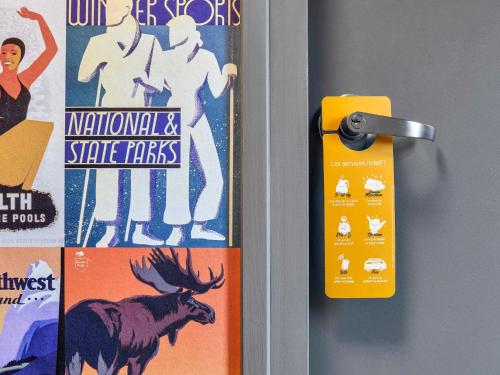 a door with a yellow tag next to a poster at hotelF1 Longwy in Longwy