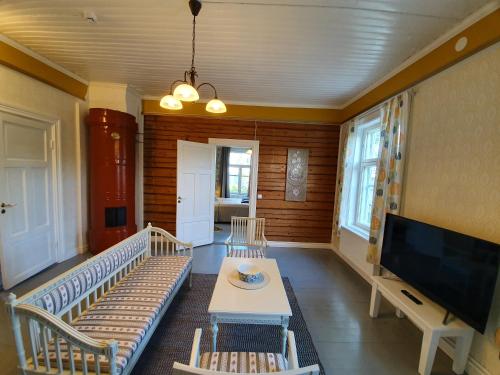 a living room with a table and chairs and a tv at B&B Taipaleenniemi in Savonlinna