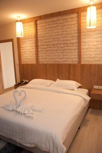 a bedroom with a bed with two swans on it at Golden City Rayong Hotel in Rayong
