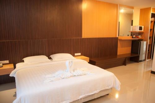 a bedroom with a bed with white towels on it at Golden City Rayong Hotel in Rayong