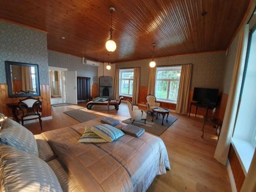 a bedroom with a large bed and a living room at B&B Taipaleenniemi in Savonlinna