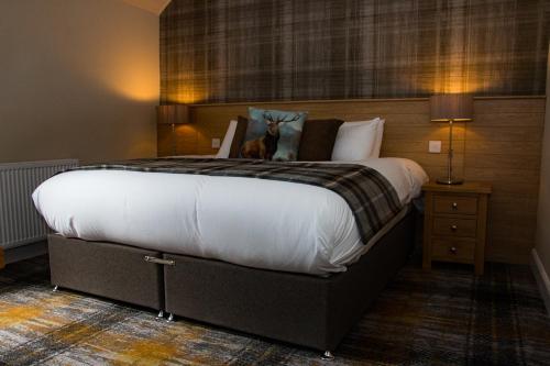 a bedroom with a large bed with a dog sitting on it at McKays Hotel in Pitlochry