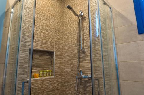 a shower with a glass door in a bathroom at Hotel Loukas Vrachos in Paralia Vrachou