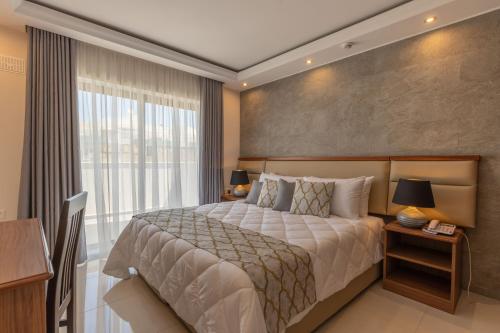 ein Schlafzimmer mit einem großen Bett und einem großen Fenster in der Unterkunft Dun Gorg Guest House in Marsaxlokk