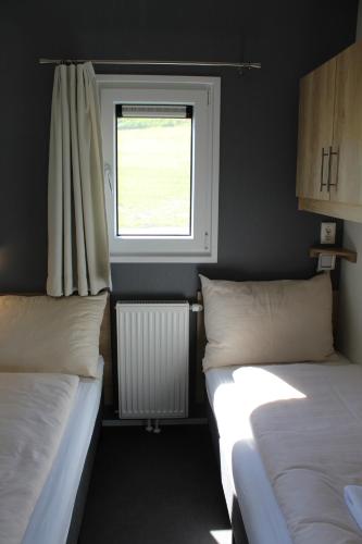 two beds in a small room with a window at Chaletpark Petzen in Feistritz ob Bleiburg