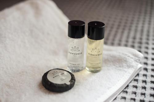 two bottles of shampoo sitting on top of a towel at Hotel Niku in Tirana