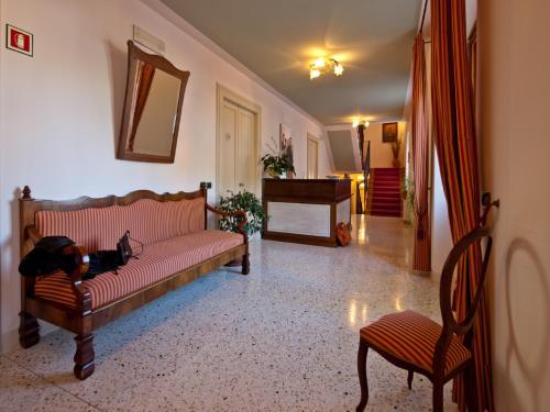 a living room with a couch and a piano at Villa Butussi - L'ospitalità del Vino in Corno di Rosazzo