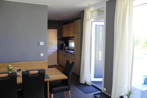 a kitchen with a wooden table and a dining room at Chaletpark Petzen in Feistritz ob Bleiburg