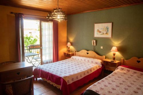 una camera con due letti e una finestra di Hotel Relais Saint Louis a Saint-Martin-Vésubie