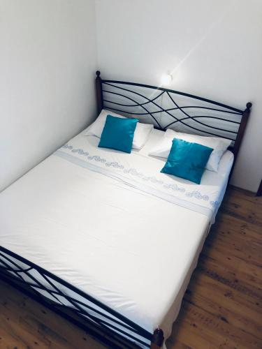 a bed with two blue pillows on top of it at Apartment Chupa in Korčula