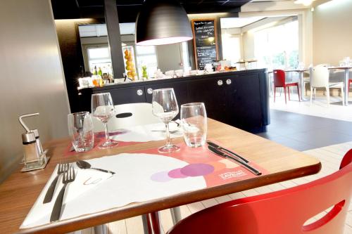 a restaurant with a table with wine glasses on it at Campanile Biarritz in Biarritz