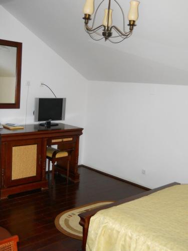 a bedroom with a desk with a computer and a bed at Casa Domneasca in Curtea de Argeş