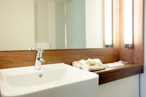 y baño con lavabo blanco y espejo. en Campanile Carcassonne Est - La Cité, en Carcassonne