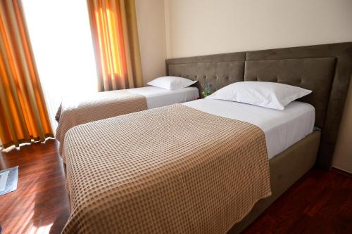 two beds in a hotel room with at Hotel Niku in Tirana