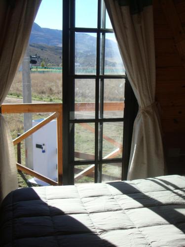 um quarto com uma cama em frente a uma janela em La Ñata em Tornquist