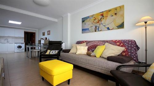 ラスパルマス・デ・グランカナリアにあるMarLenghi Apartments 3Bのリビングルーム(ソファ、黄色のスツール付)